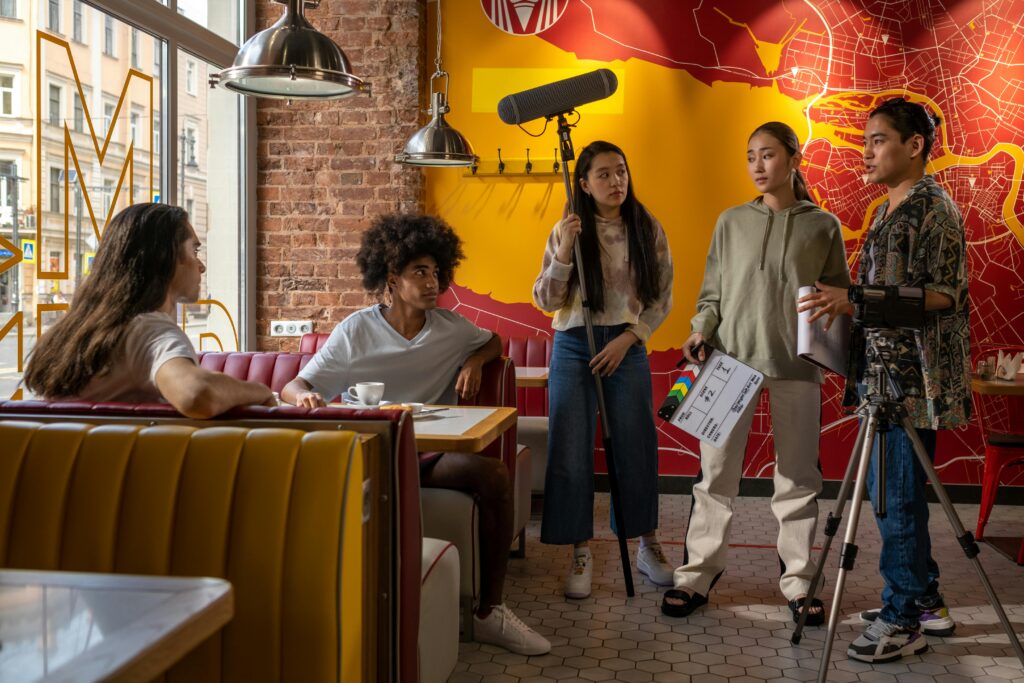 Film crew collaborating in a trendy urban cafe, capturing casual scenes.